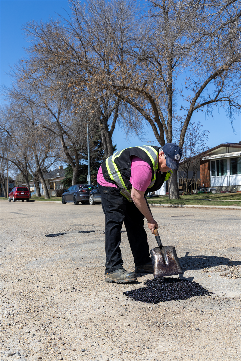 A person filling a pothole
