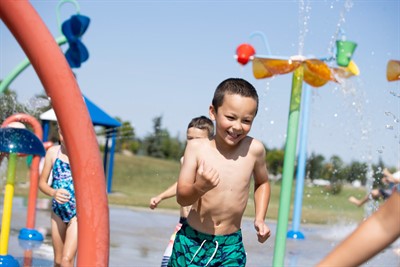 Kid running through a fountain at the splash park